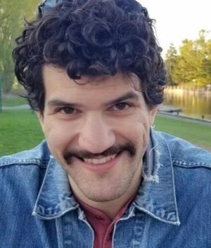 Juan Escobar-Lamanna outside wearing a jean jacket and smiling