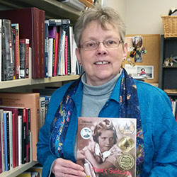 Photo of Lynne McKechnie holding a children's book
